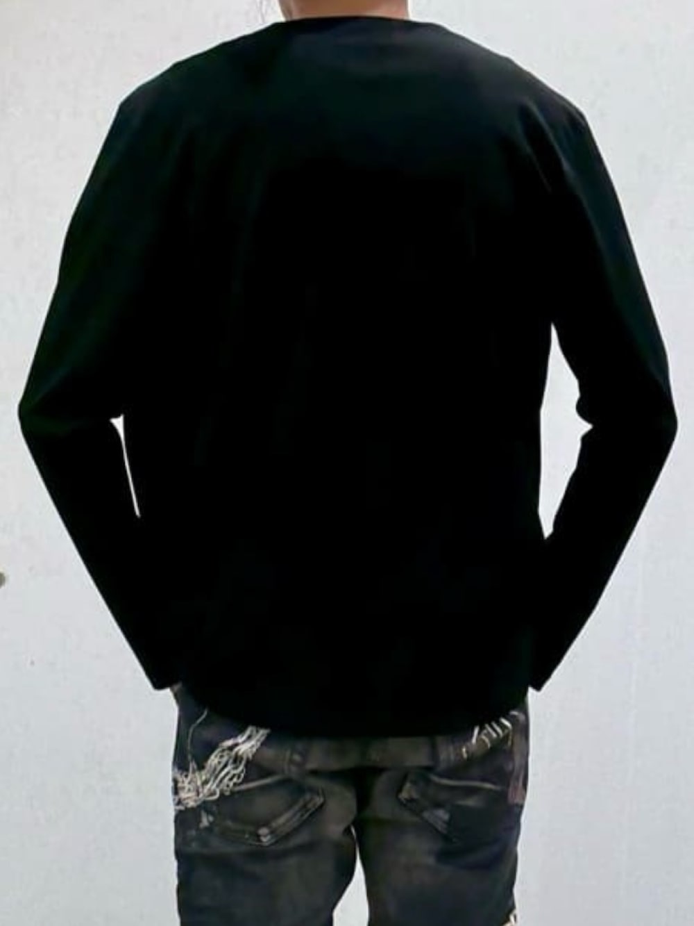ブラック系のTシャツ/カットソー、ホワイト系のスニーカー、ブラック系のデニムパンツを着用したメンズの春コーディネートの7枚目の写真