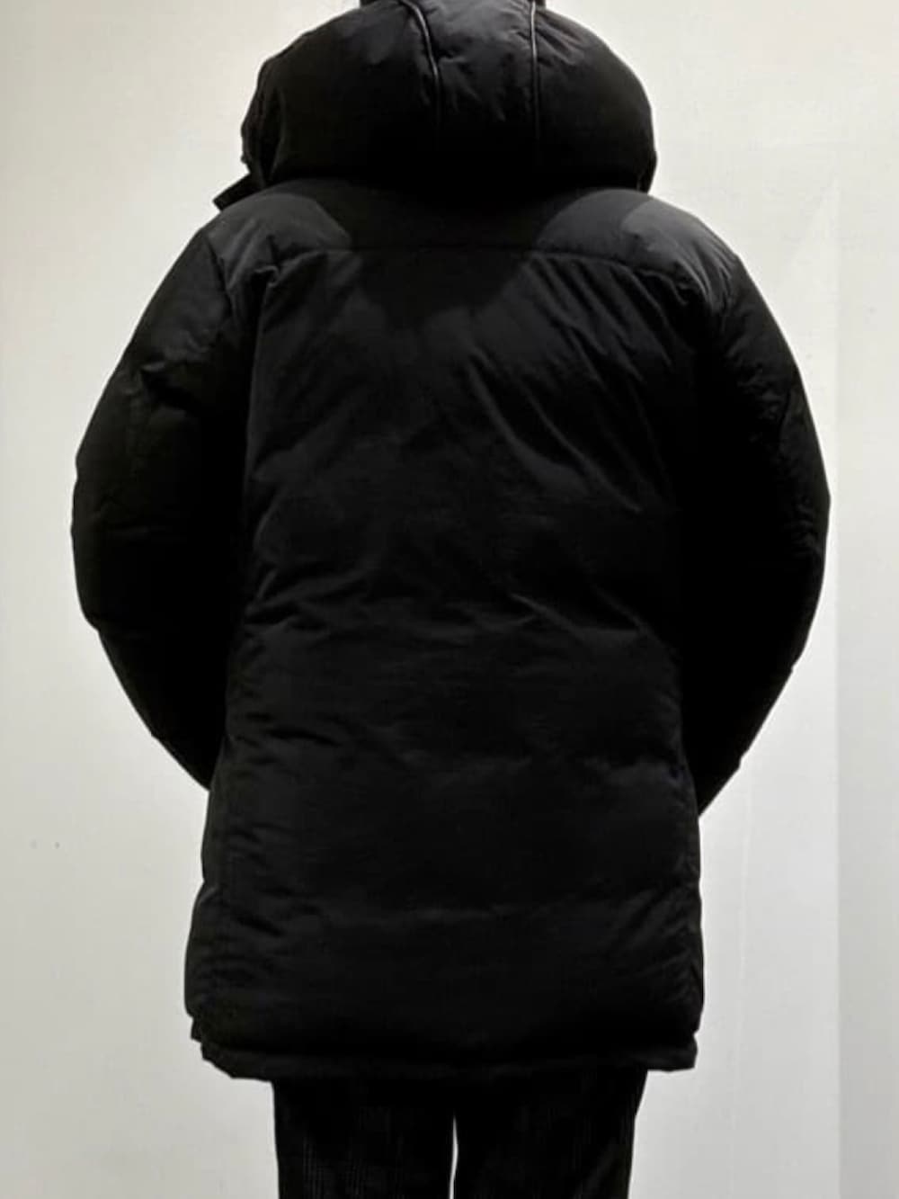 ブラック系のTシャツ/カットソー、ブラック系のダウンジャケット/コート、ブラック系のスリッポンを着用したメンズの夏コーディネートの4枚目の写真