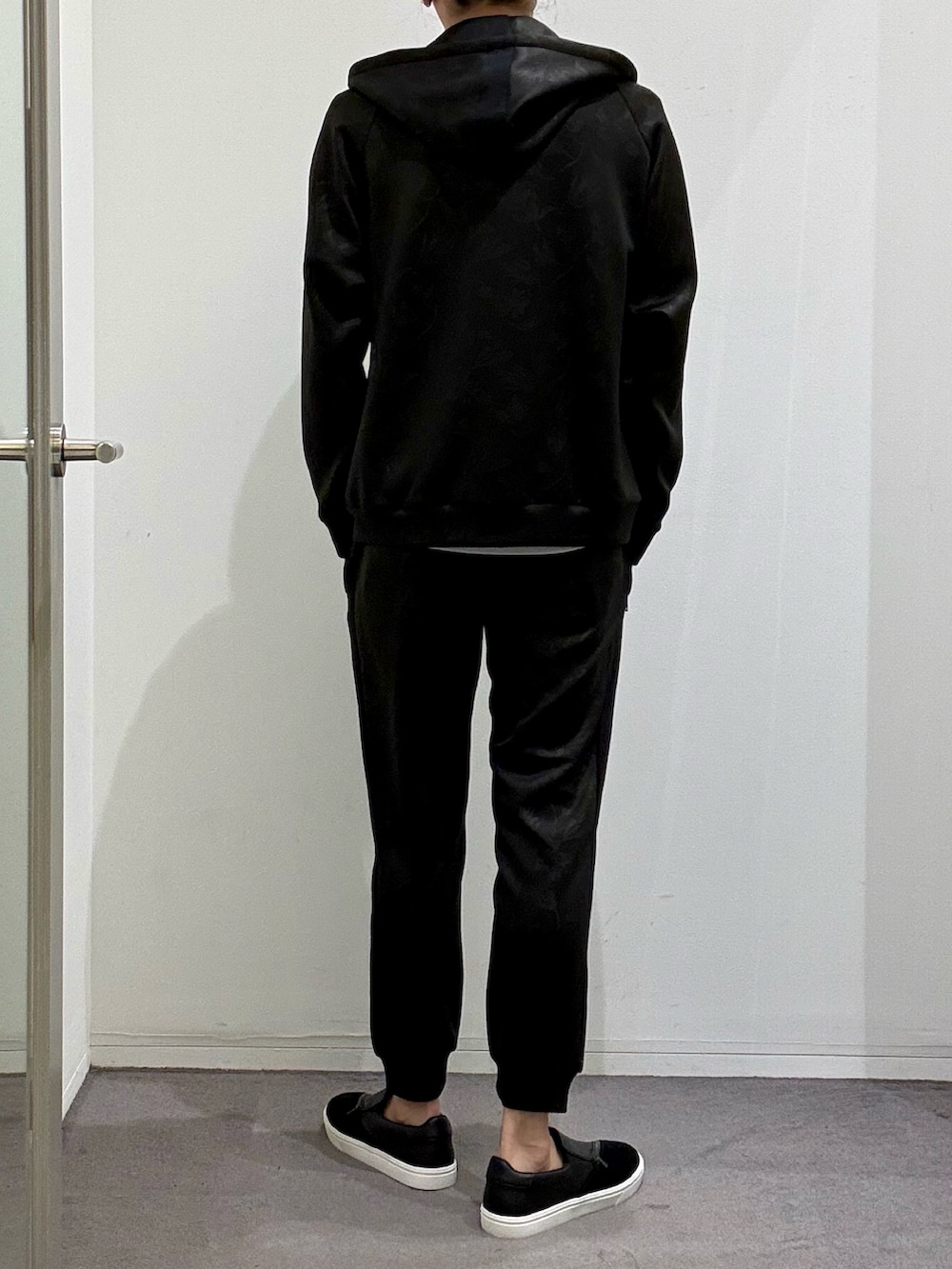ブラック系のパーカー、ブラック系のスウェットパンツ、ブラック系のスニーカーを着用したメンズの春コーディネートの3枚目の写真
