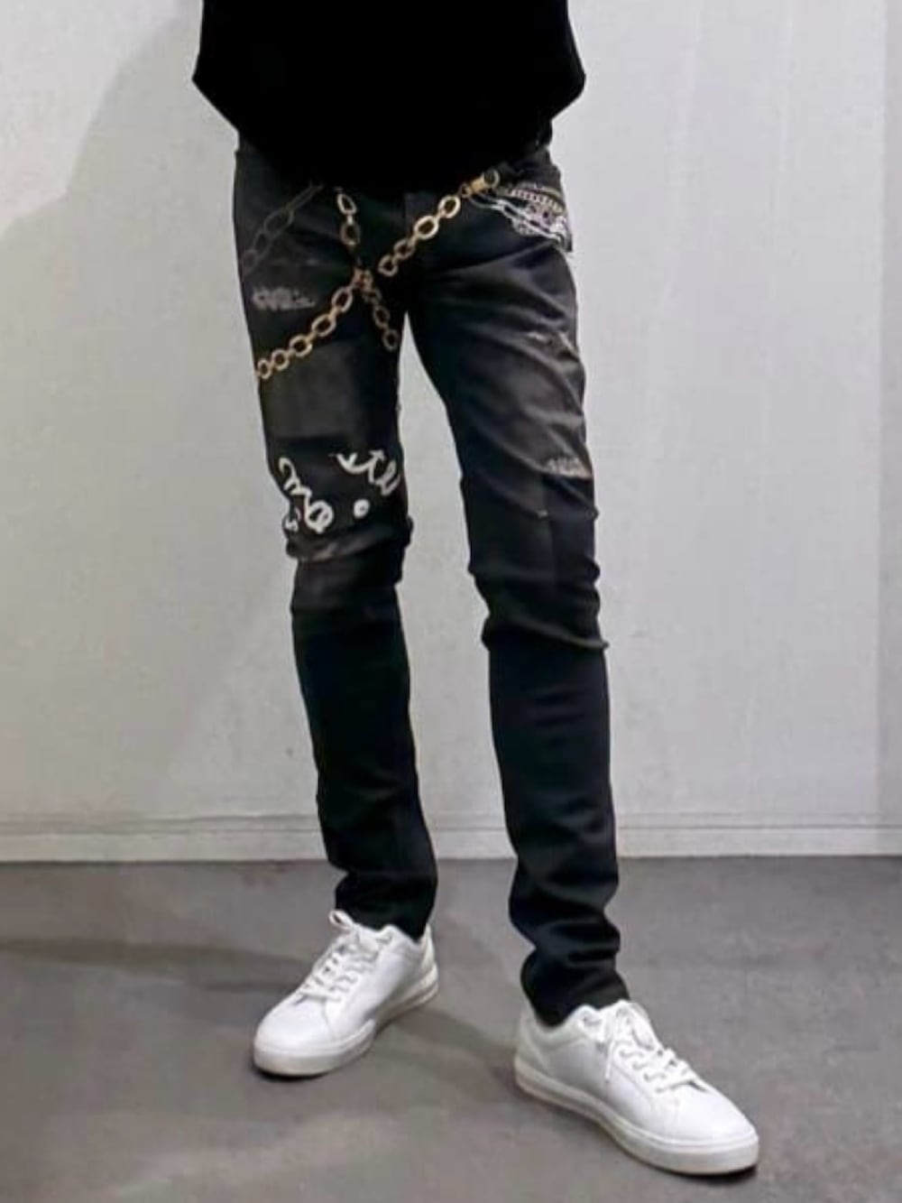 ブラック系のTシャツ/カットソー、ホワイト系のスニーカー、ブラック系のデニムパンツを着用したメンズの春コーディネートの8枚目の写真