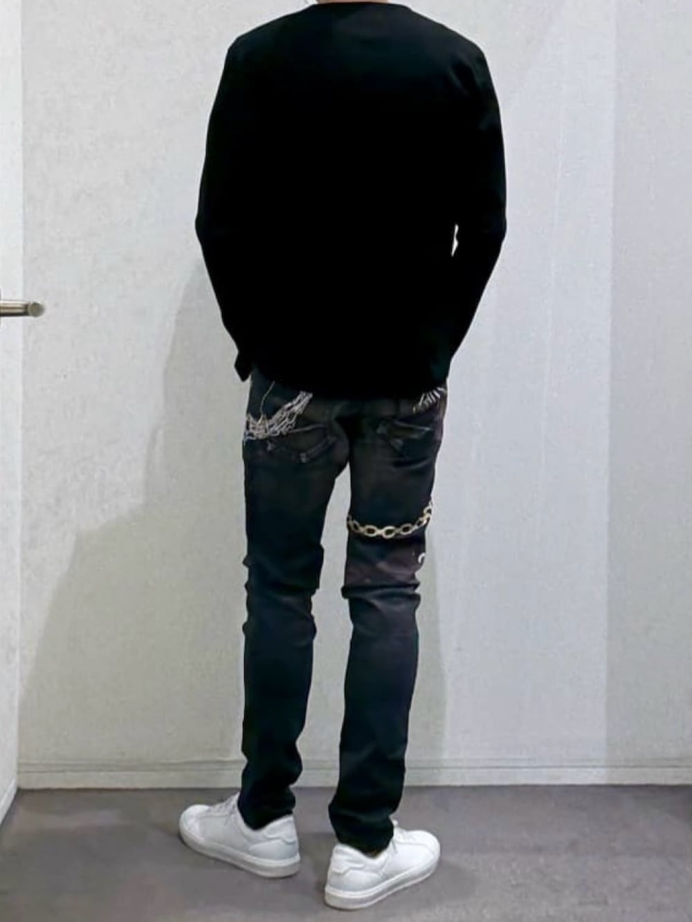 ブラック系のTシャツ/カットソー、ホワイト系のスニーカー、ブラック系のデニムパンツを着用したメンズの春コーディネートの3枚目の写真