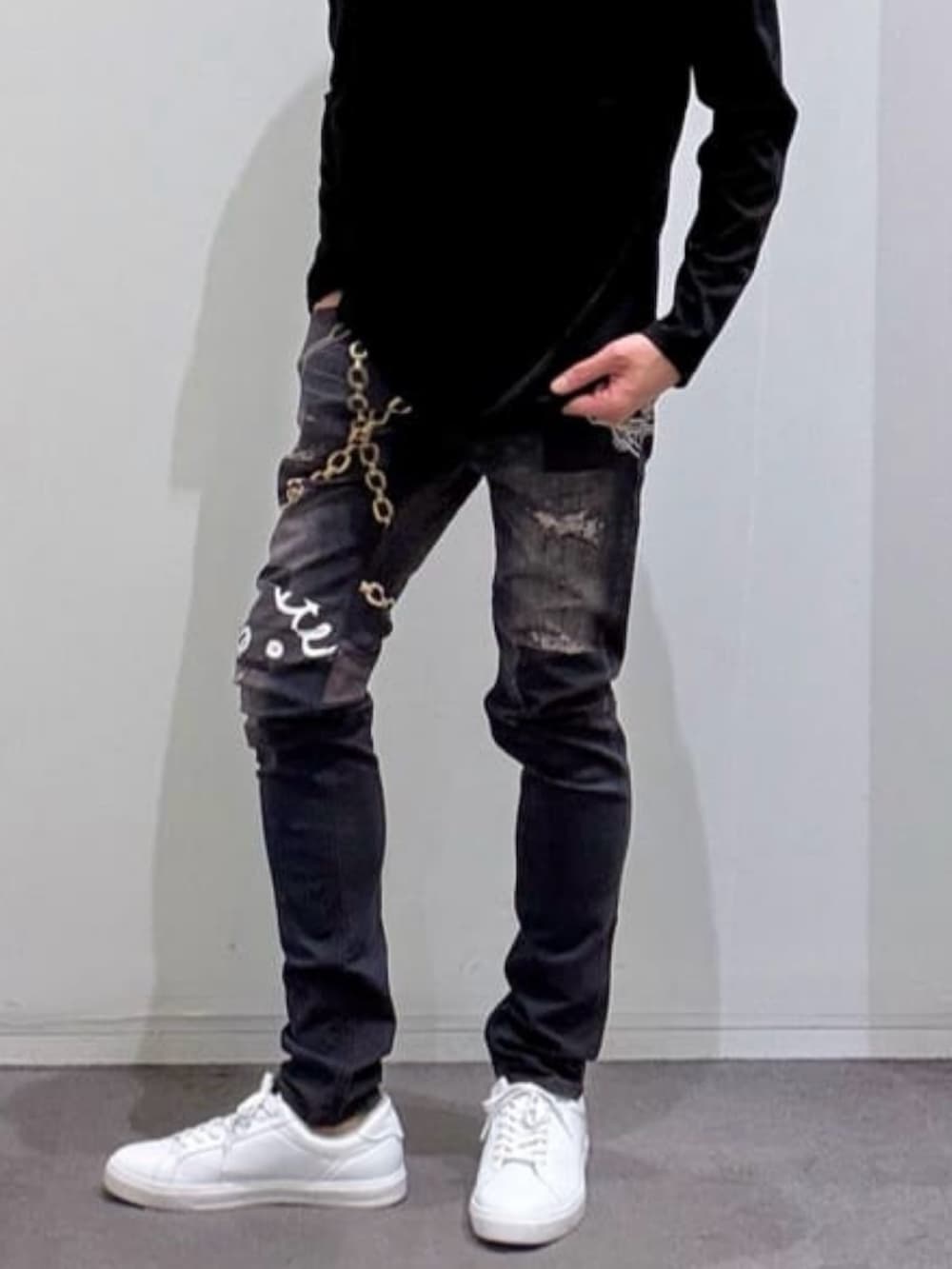 ブラック系のTシャツ/カットソー、ホワイト系のスニーカー、ブラック系のデニムパンツを着用したメンズの春コーディネートの5枚目の写真