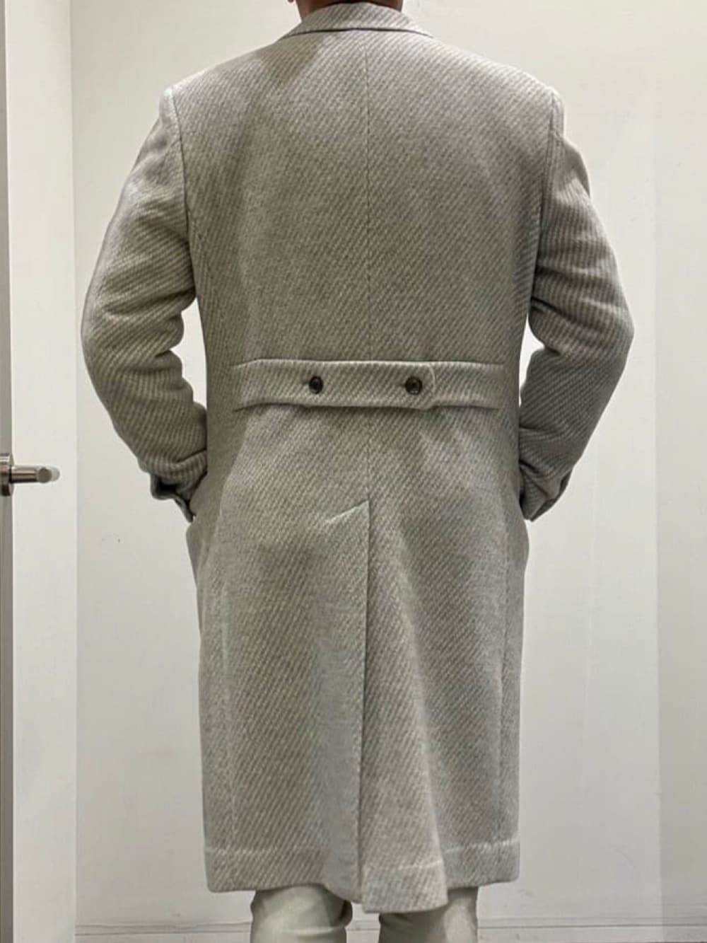 グレー系のチェスターコート、ブラック系のライダースジャケット、グリーン系のTシャツ/カットソーを着用したメンズの秋コーディネートの3枚目の写真
