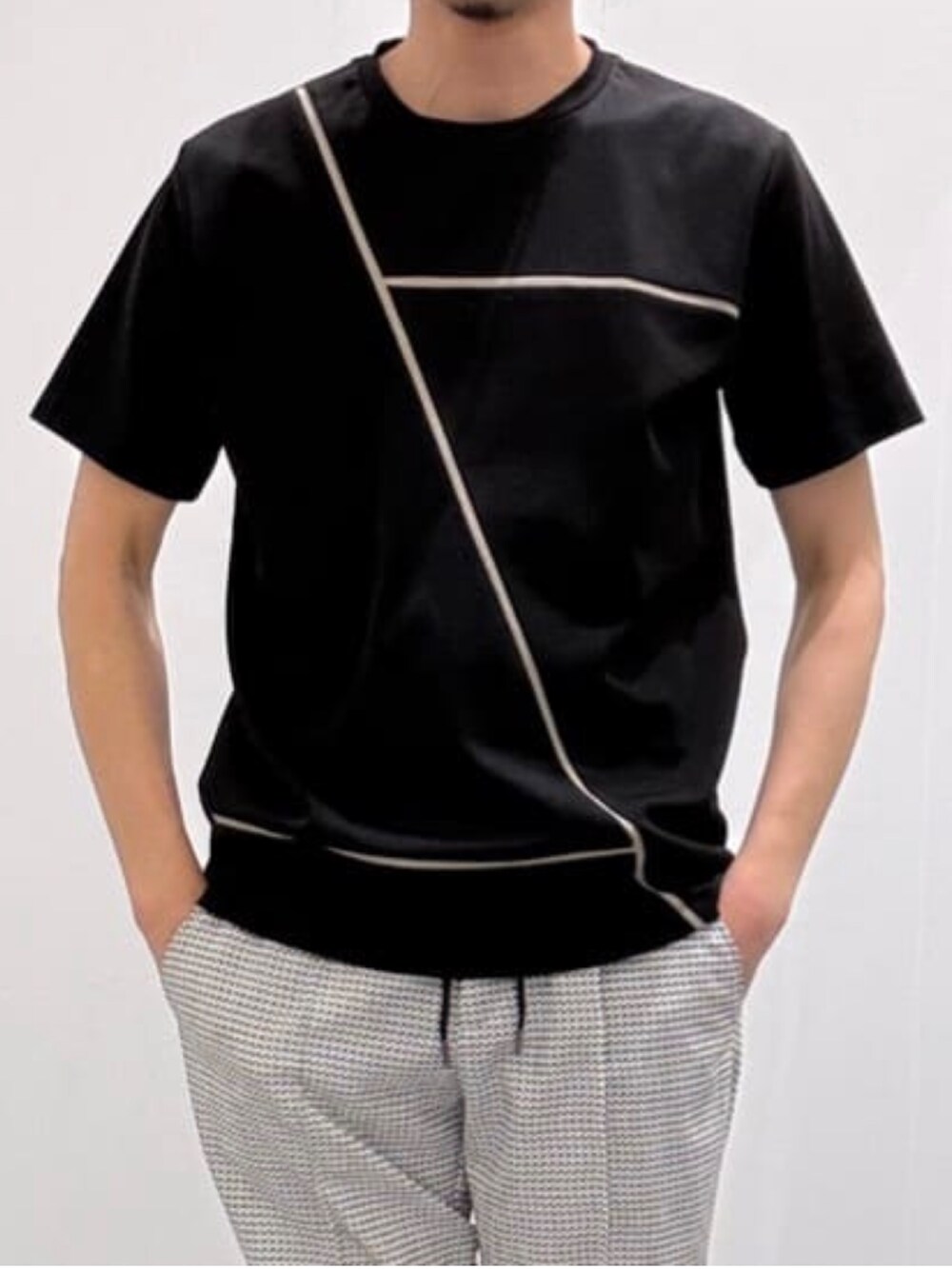 ブラック系のスリッポン、ホワイト系のスラックス、ブラック系のTシャツ/カットソーを着用したメンズの夏コーディネートの7枚目の写真