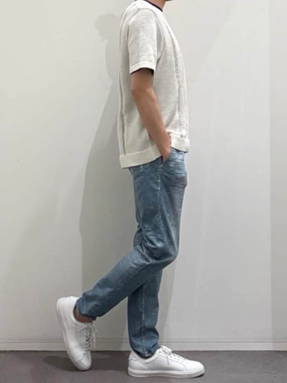 ホワイト系のスニーカー、ホワイト系のニット/セーター、ブルー系のデニムパンツを着用したメンズの春コーディネートの2枚目の写真