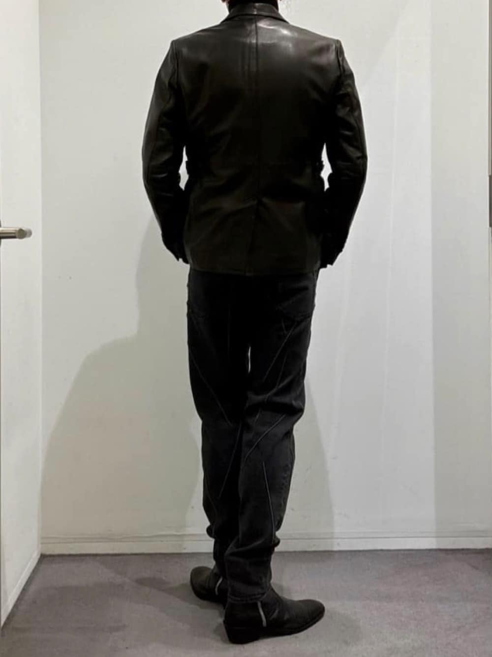 ブラック系のその他パンツ、ブラック系のブーツ、ブラック系のテーラードジャケットを着用したメンズの秋コーディネートの4枚目の写真