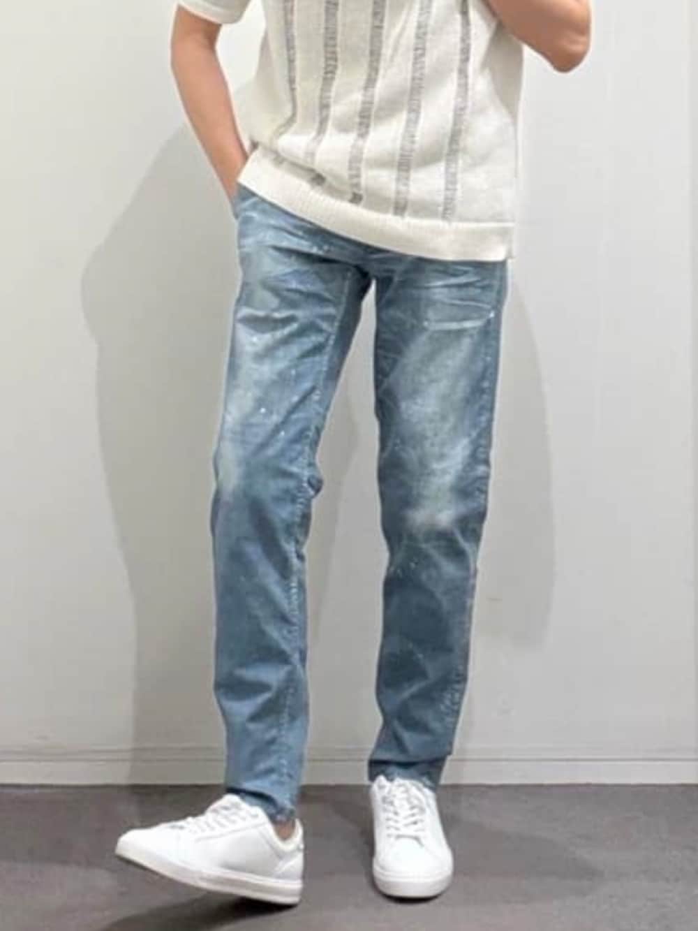 ホワイト系のスニーカー、ホワイト系のニット/セーター、ブルー系のデニムパンツを着用したメンズの春コーディネートの5枚目の写真