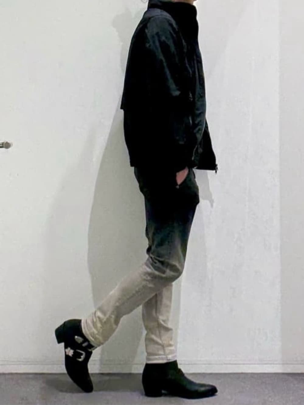 ブラック系のブルゾン、ベージュ系のTシャツ/カットソー、ブラック系のブーツを着用したメンズの春コーディネートの2枚目の写真