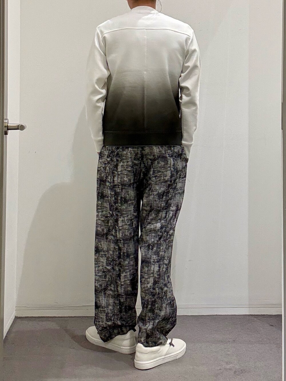 ホワイト系のスニーカー、ブラック系のその他パンツ、ホワイト系のTシャツ/カットソーを着用したメンズの春コーディネートの3枚目の写真