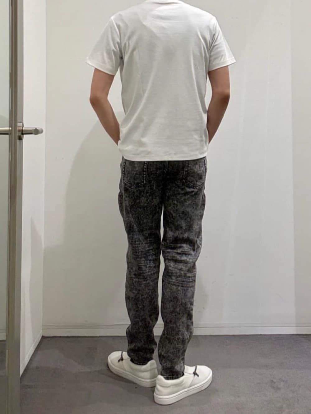 ホワイト系のスニーカー、ホワイト系のTシャツ/カットソー、ブラック系のデニムパンツを着用したメンズの夏コーディネートの4枚目の写真