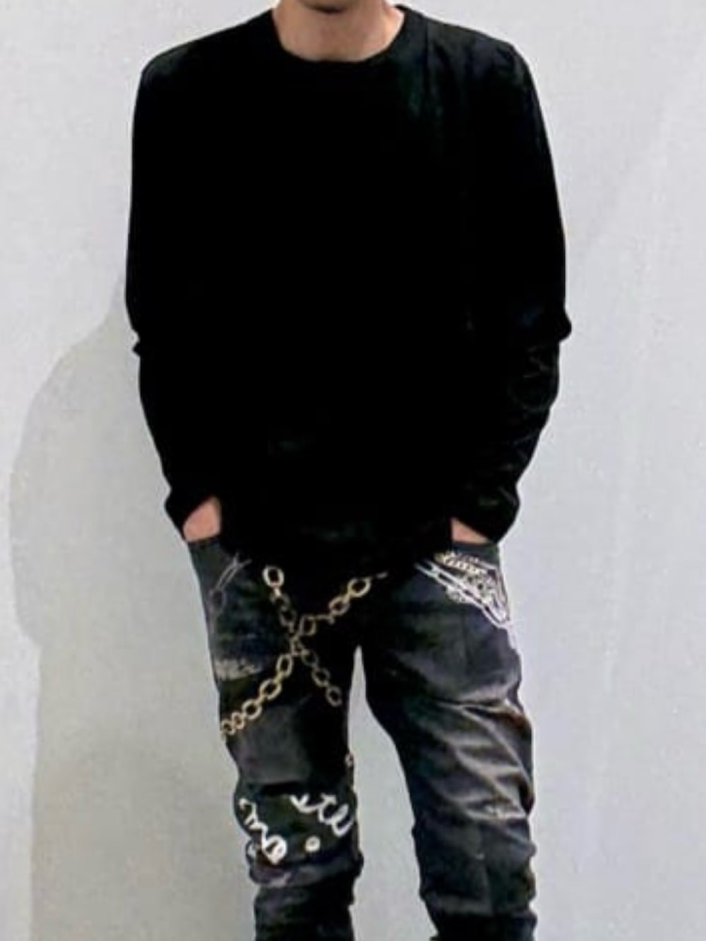 ブラック系のTシャツ/カットソー、ホワイト系のスニーカー、ブラック系のデニムパンツを着用したメンズの春コーディネートの4枚目の写真