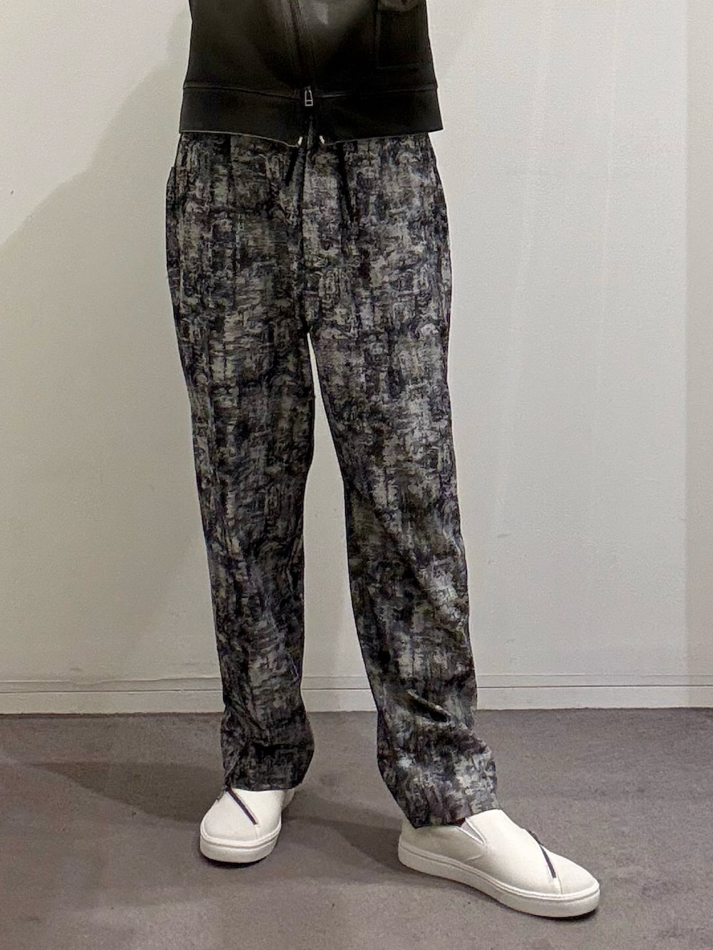 ホワイト系のスニーカー、ブラック系のその他パンツ、ホワイト系のTシャツ/カットソーを着用したメンズの春コーディネートの6枚目の写真