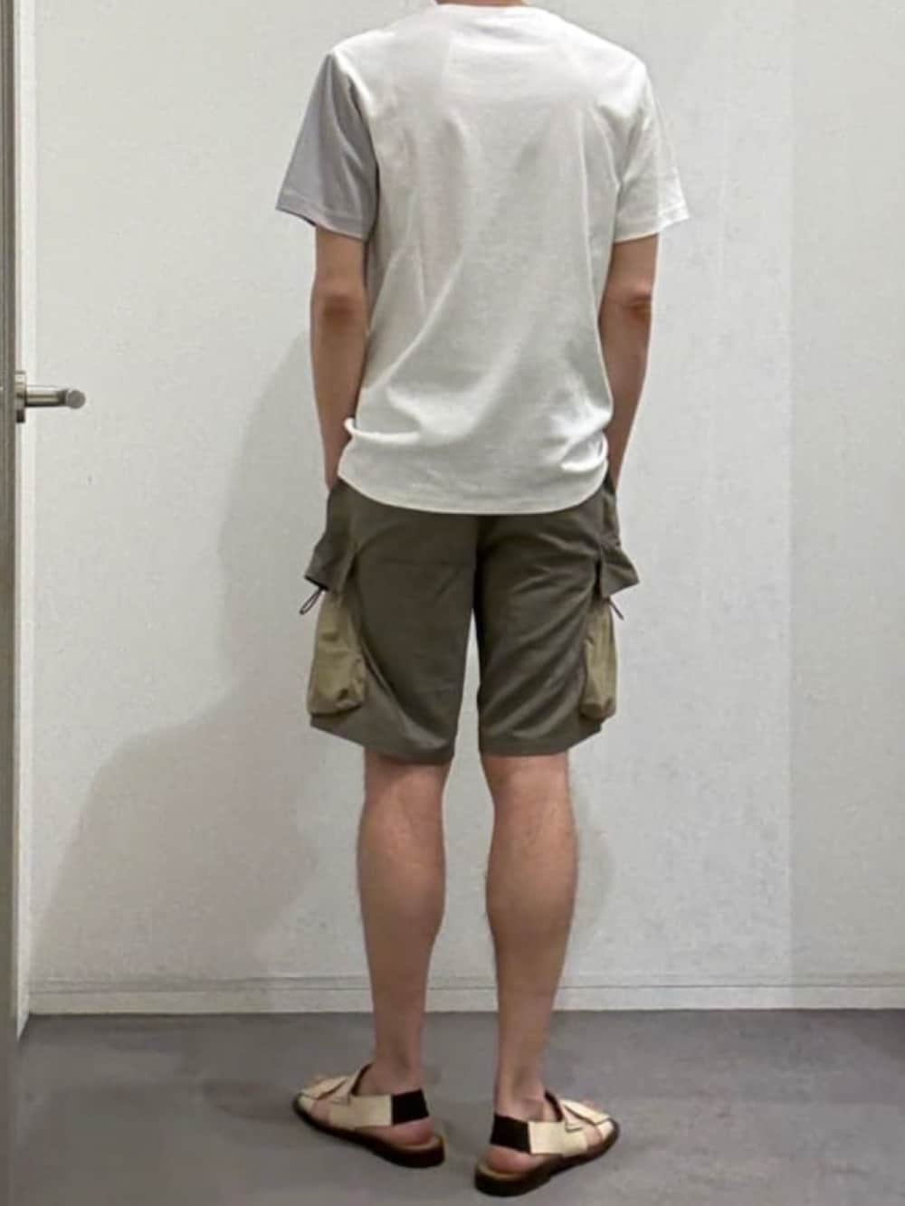 ホワイト系のTシャツ/カットソー、グリーン系のカーゴパンツ、ベージュ系のサンダルを着用したメンズの夏コーディネートの3枚目の写真