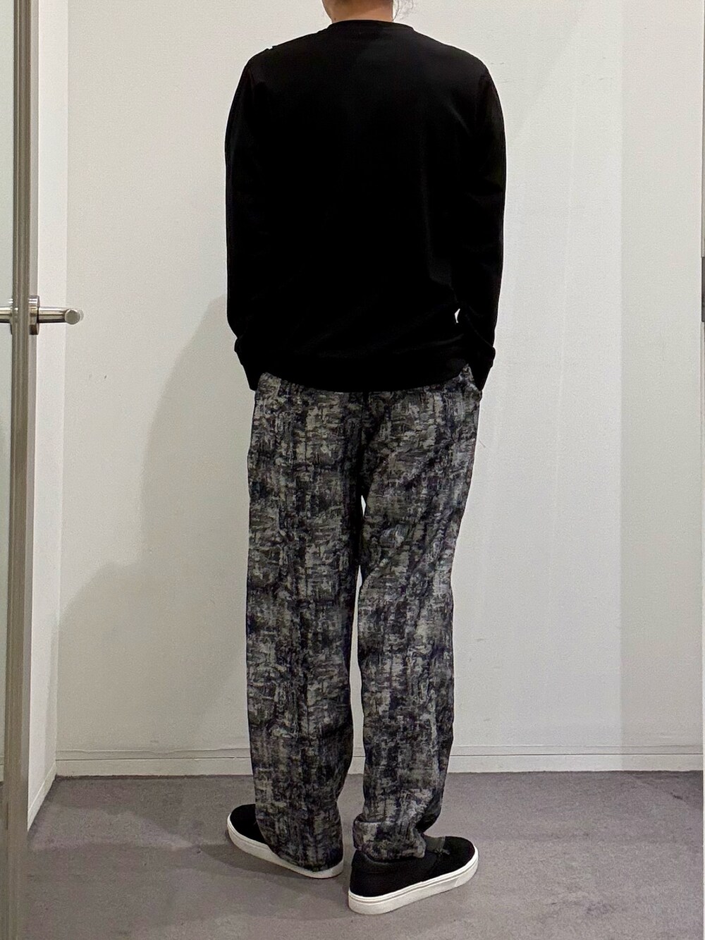 ブラック系のスニーカー、ブラック系のTシャツ/カットソー、ブラック系のその他パンツを着用したメンズの春コーディネートの3枚目の写真