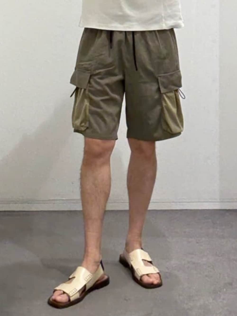 ホワイト系のTシャツ/カットソー、グリーン系のカーゴパンツ、ベージュ系のサンダルを着用したメンズの夏コーディネートの8枚目の写真