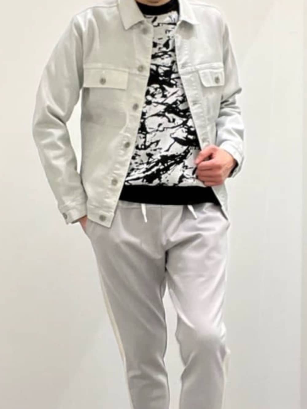 シルバー系のデニムジャケット、ブラック系のニット/セーター、グレー系のスウェットパンツを着用したメンズの夏コーディネートの5枚目の写真
