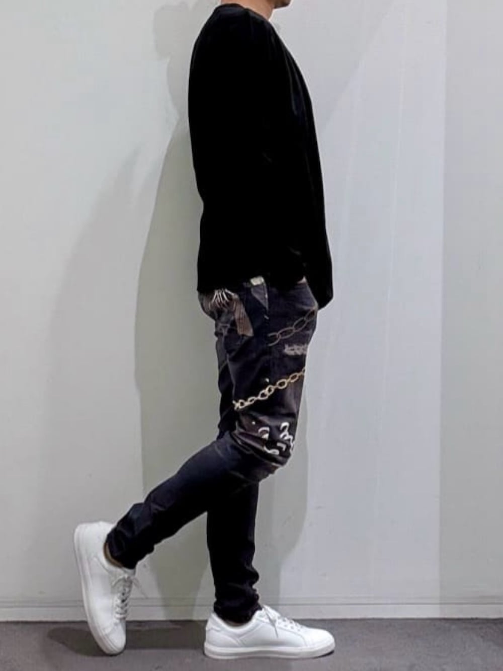ブラック系のTシャツ/カットソー、ホワイト系のスニーカー、ブラック系のデニムパンツを着用したメンズの春コーディネートの2枚目の写真