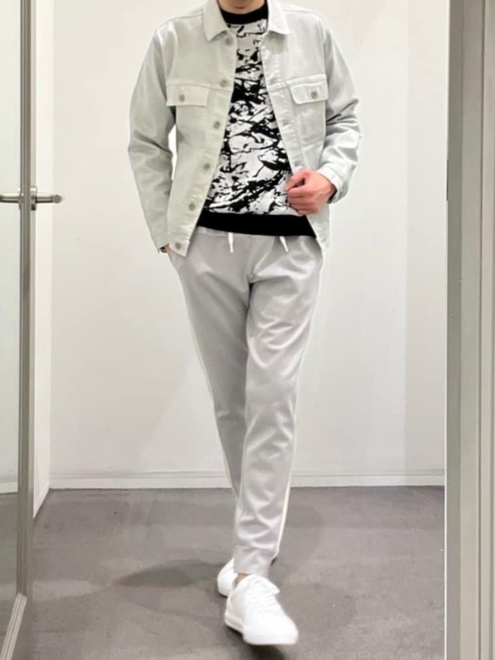 シルバー系のデニムジャケット、ブラック系のニット/セーター、グレー系のスウェットパンツを着用したメンズの夏コーディネートの2枚目の写真
