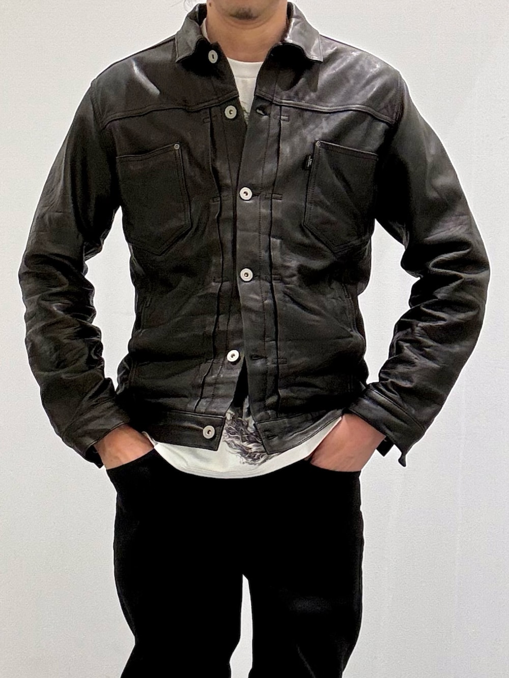 ブラック系のライダースジャケット、ホワイト系のTシャツ/カットソー、ホワイト系のスニーカーを着用したメンズの春コーディネートの5枚目の写真