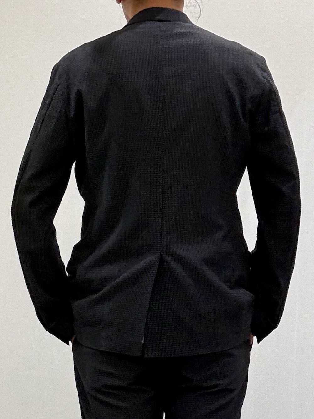 ホワイト系のTシャツ/カットソー、グレー系のテーラードジャケット、ブラック系のスリッポンを着用したメンズの春コーディネートの6枚目の写真