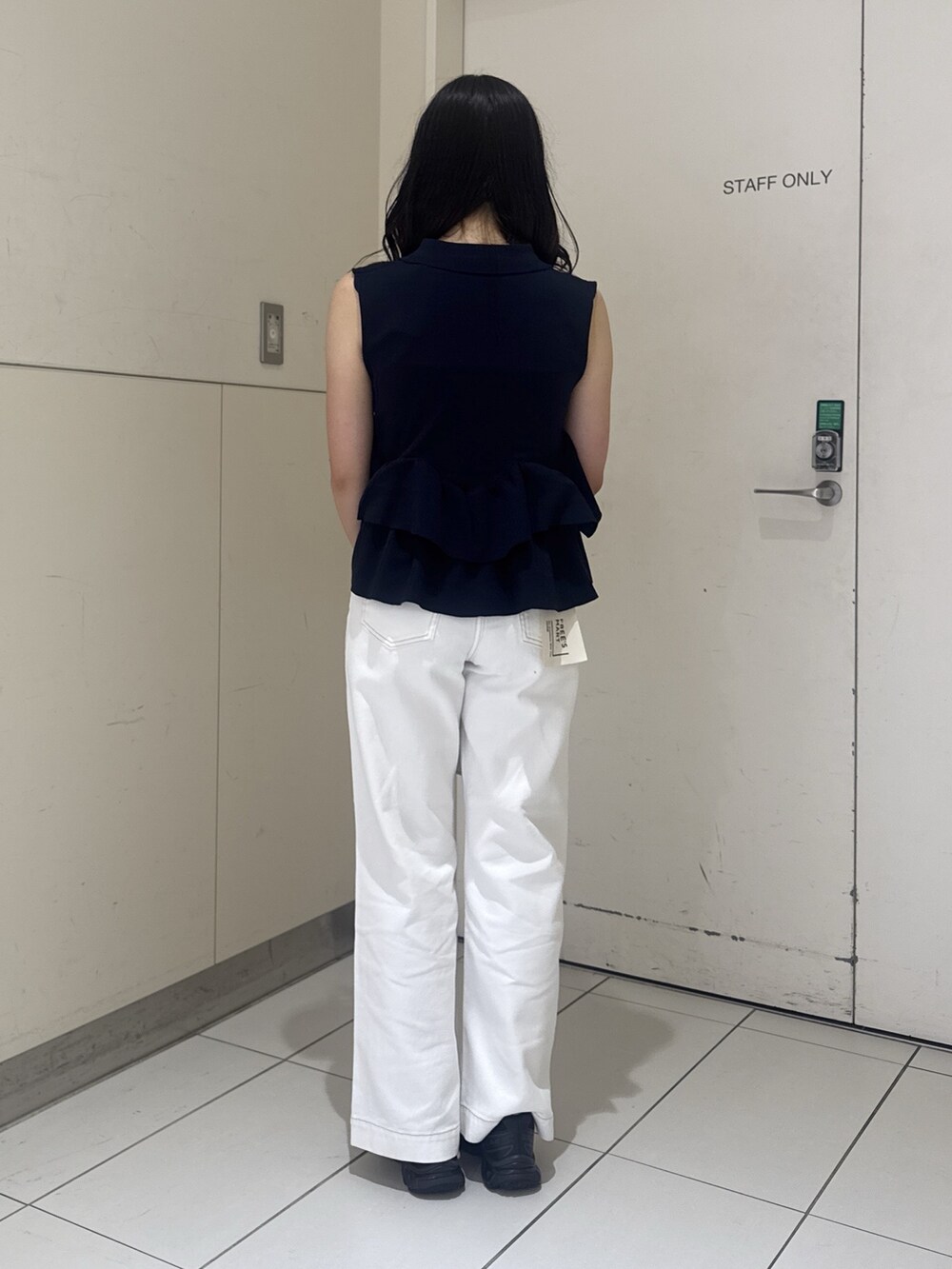 ブルー系のニット/セーター、ホワイト系のデニムパンツ、シルバー系のショルダーバッグを着用したレディースの夏コーディネートの4枚目の写真