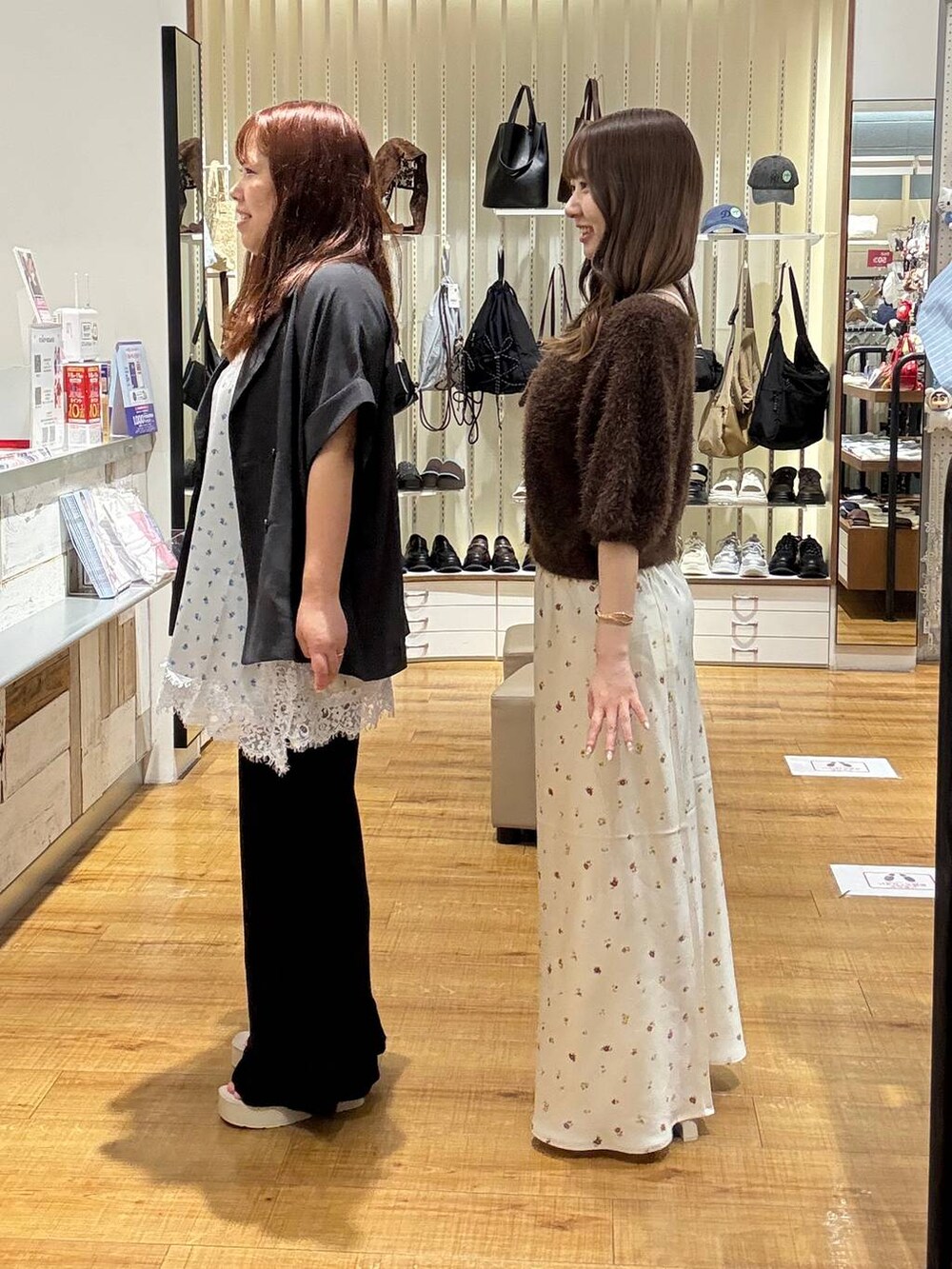 ブラウン系のカーディガン/ボレロ、ホワイト系のスカート、ホワイト系のサンダルを着用したレディースの秋コーディネートの2枚目の写真