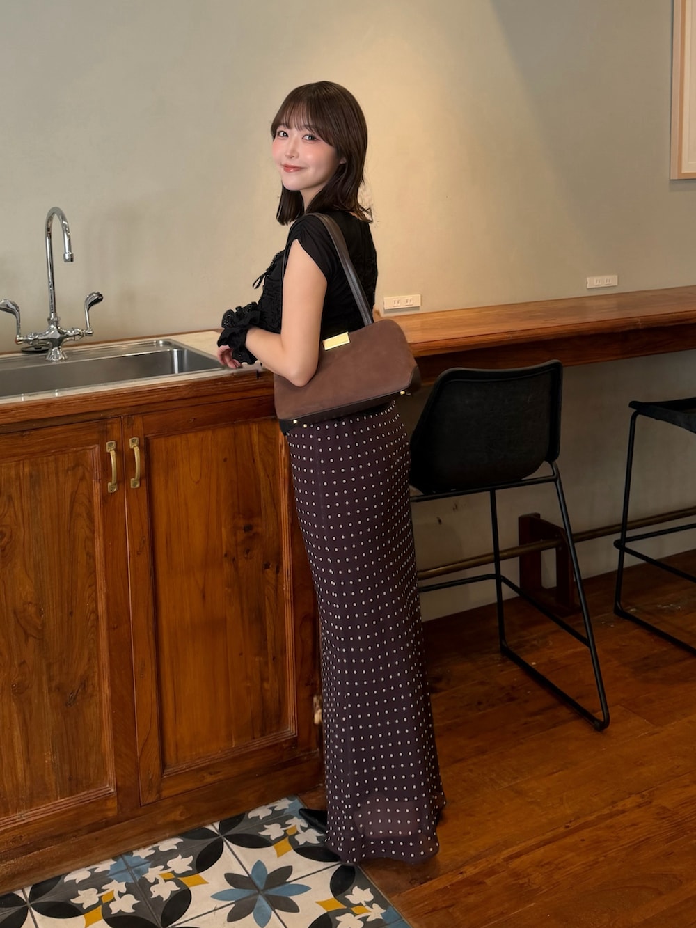 ブラウン系のスカート、ブラウン系のバッグ、ブルー系のシャツ/ブラウスを着用したレディースの秋コーディネートの2枚目の写真