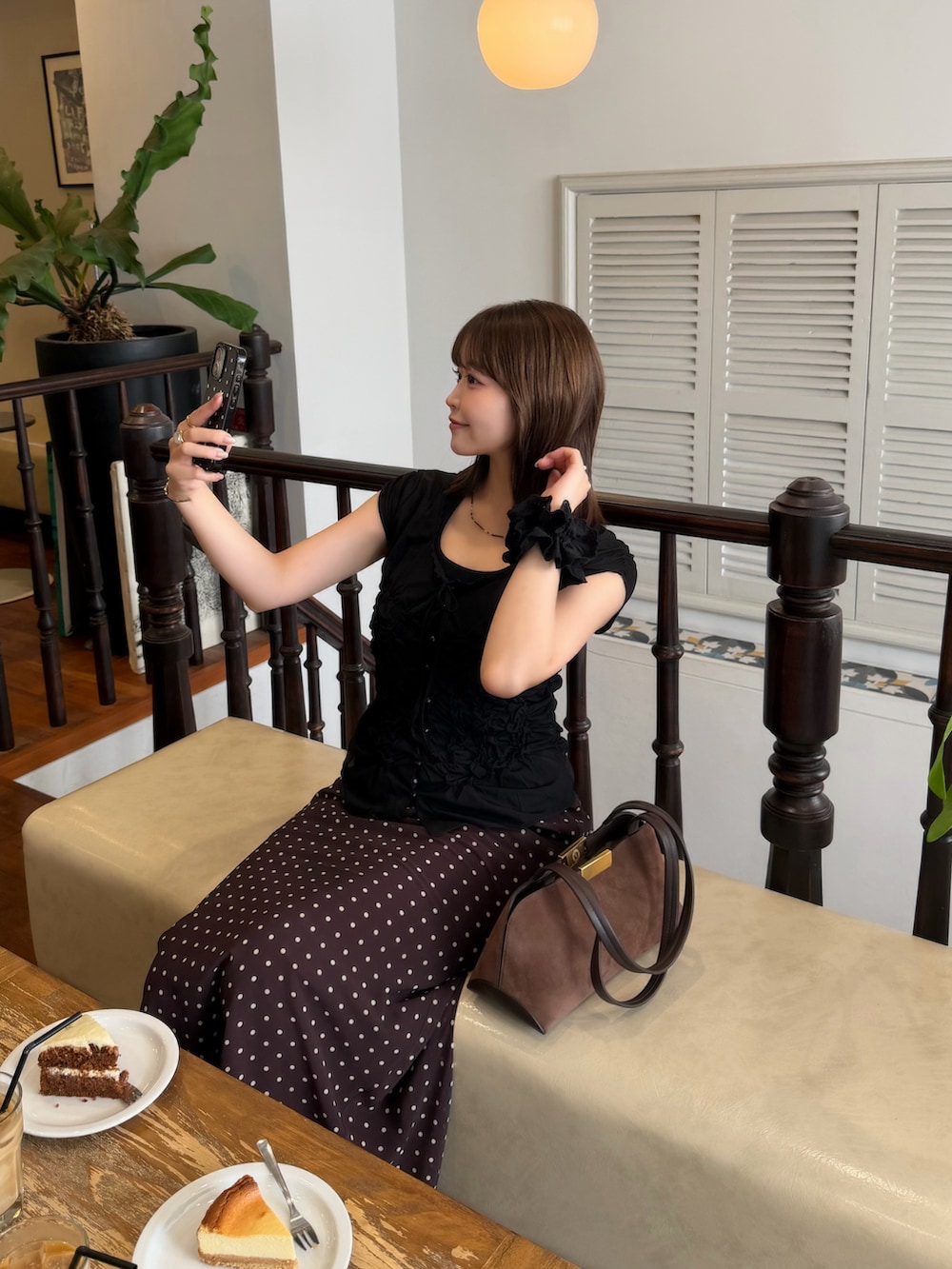ブラウン系のスカート、ブラウン系のバッグ、ブルー系のシャツ/ブラウスを着用したレディースの秋コーディネートの3枚目の写真