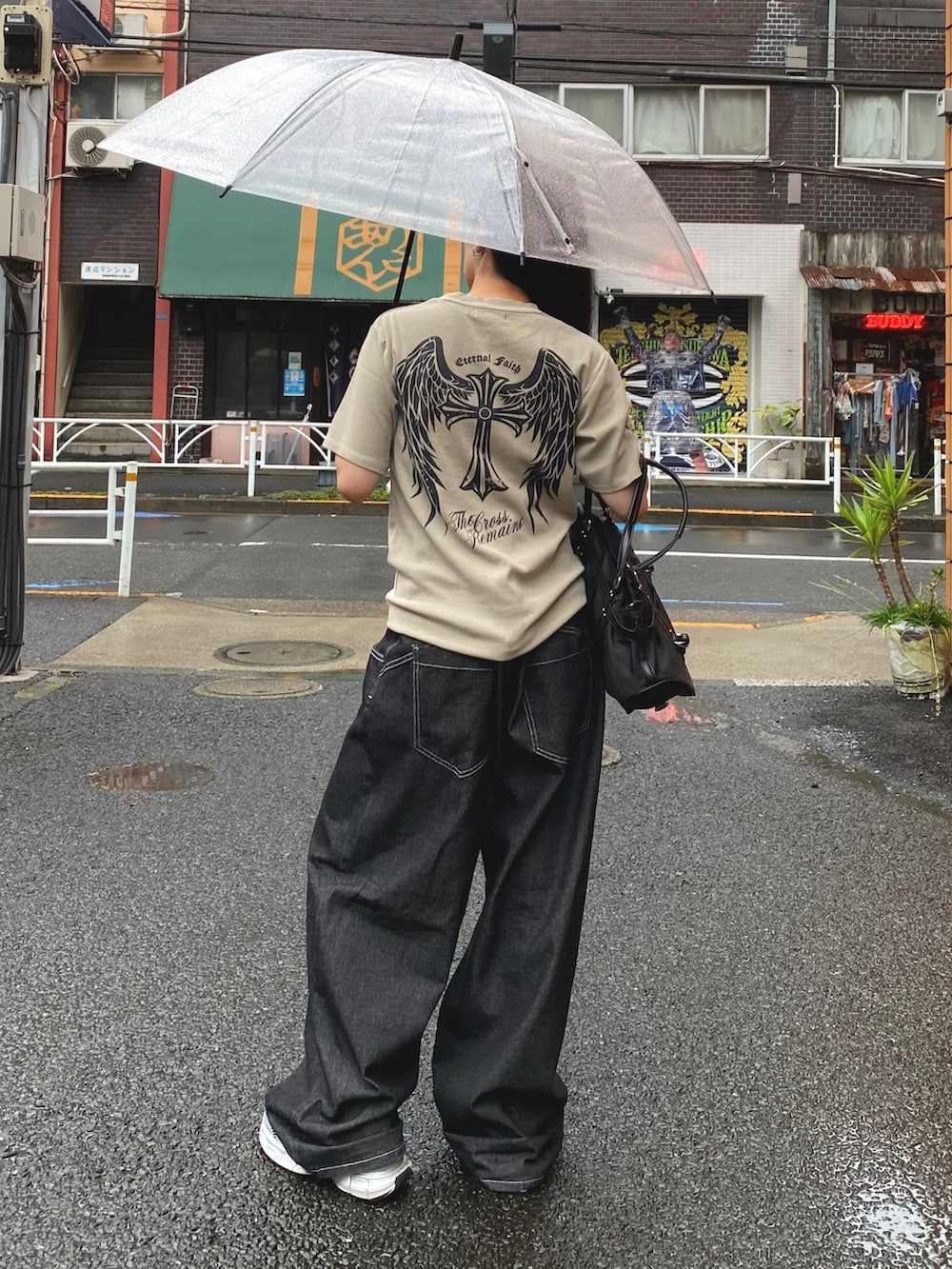 グレー系のTシャツ/カットソー、ブラック系のデニムパンツ、シルバー系のスニーカーを着用したレディースの夏コーディネートの2枚目の写真