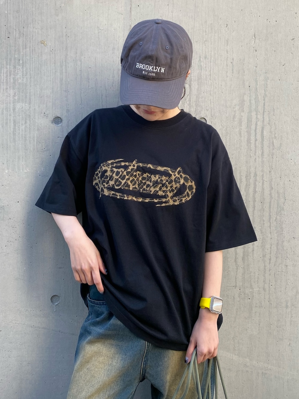 ブラック系のTシャツ/カットソー、グリーン系のバックパック/リュック、ブルー系のデニムパンツを着用したレディースの夏コーディネートの2枚目の写真