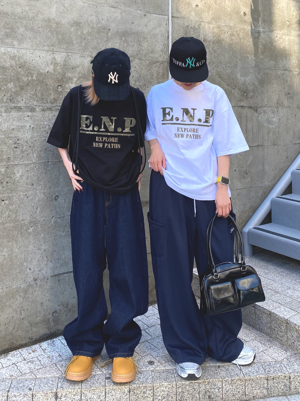 ホワイト系のTシャツ/カットソー、ブルー系のスウェットパンツ、ブラック系のボストンバッグを着用したレディースの夏コーディネートの2枚目の写真