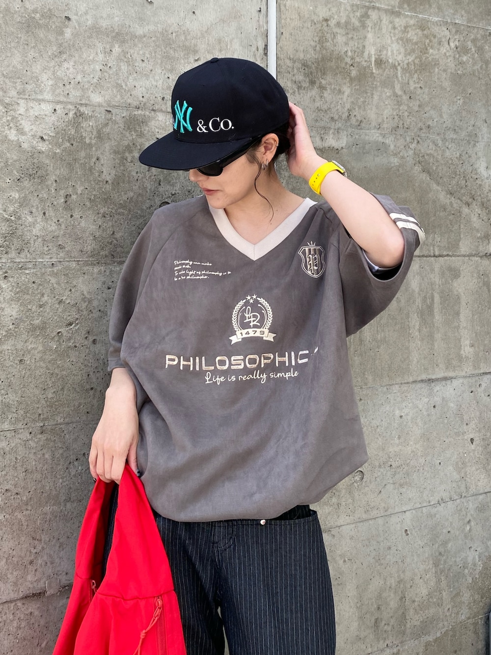 グレー系のTシャツ/カットソー、ブラック系のデニムパンツ、レッド系のショルダーバッグを着用したレディースの春コーディネートの2枚目の写真