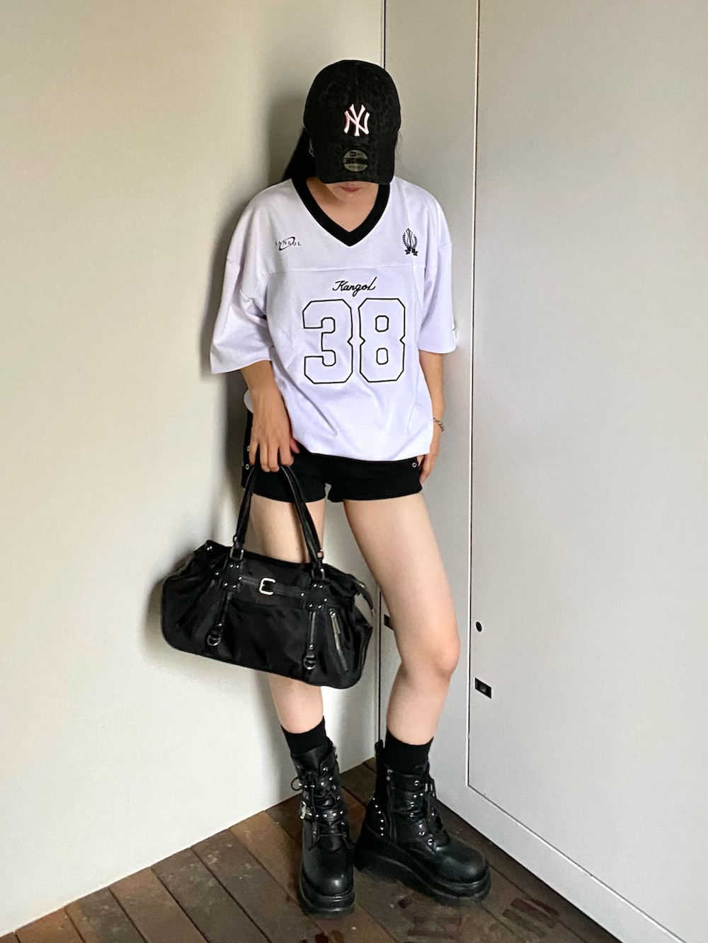 ホワイト系のTシャツ/カットソー、ブラック系のデニムパンツ、ブラック系のショルダーバッグを着用したレディースの夏コーディネートの2枚目の写真
