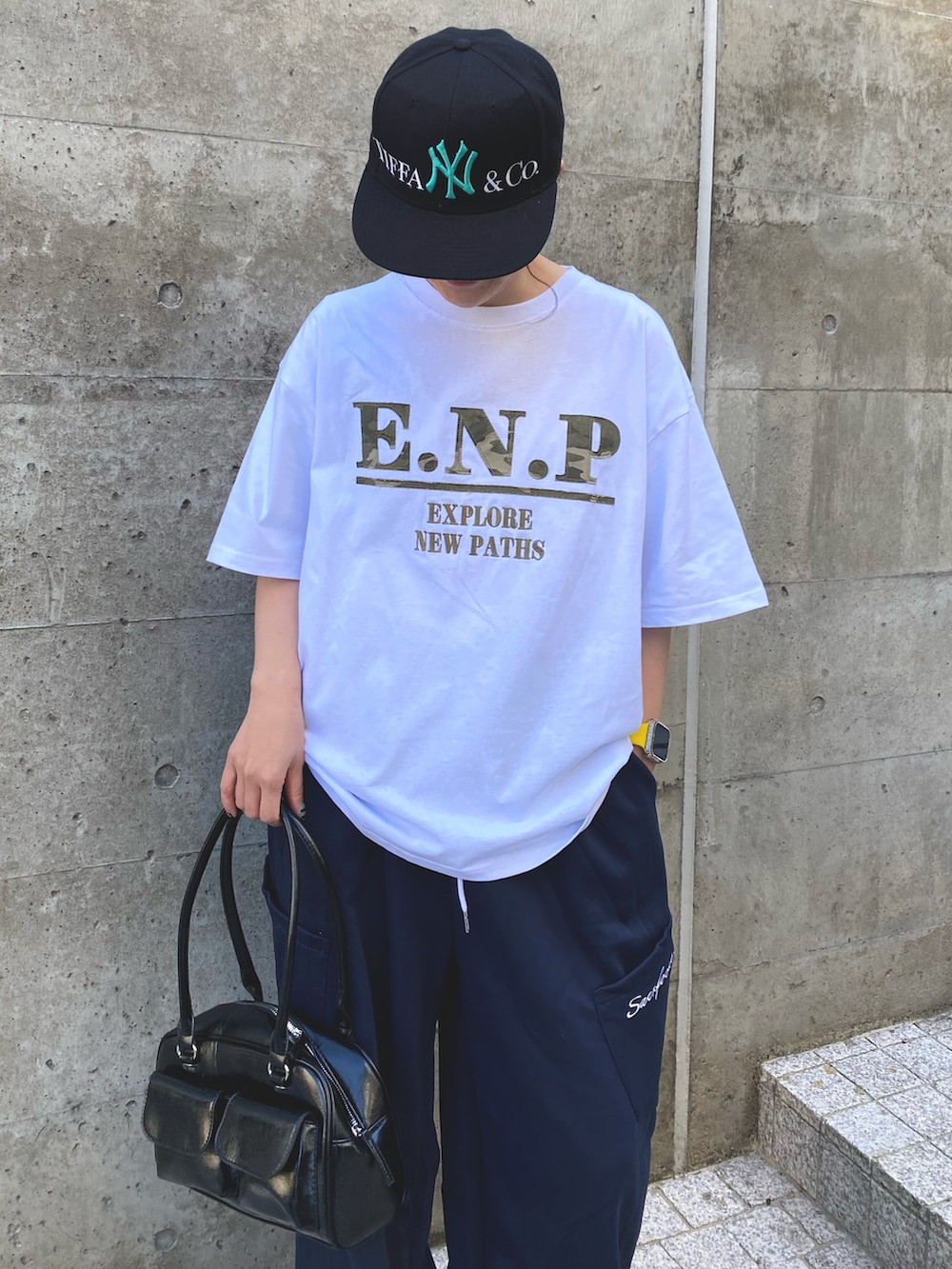 ホワイト系のTシャツ/カットソー、ブルー系のスウェットパンツ、ブラック系のボストンバッグを着用したレディースの夏コーディネートの3枚目の写真