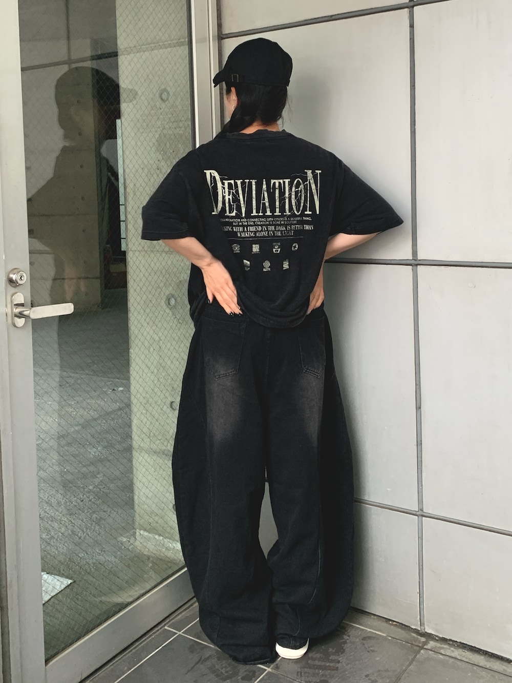 ブラック系のTシャツ/カットソー、ブラック系のデニムパンツ、ブラック系のスニーカーを着用したレディースの夏コーディネートの2枚目の写真