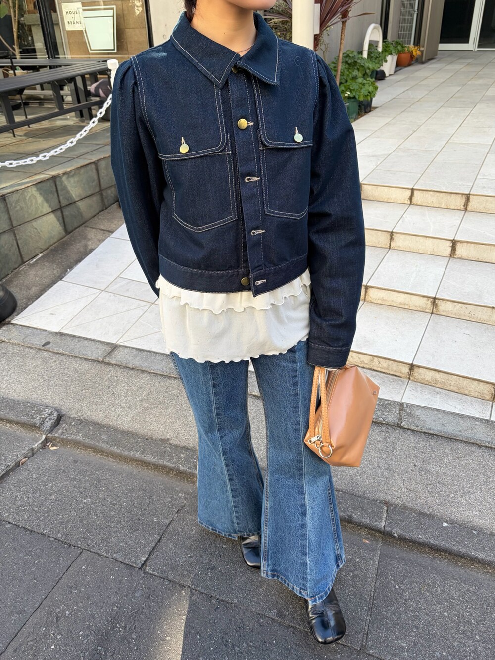 ホワイト系のTシャツ/カットソー、ブルー系のデニムジャケット、ブラック系のブーツを着用したレディースの冬コーディネートの5枚目の写真