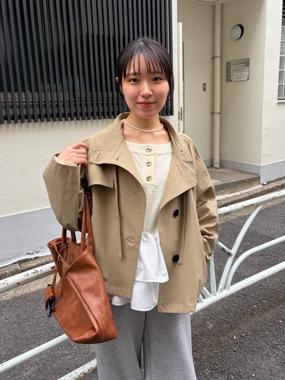 グレー系のスウェットパンツ、ブラウン系のブーツ、イエロー系のトートバッグを着用したレディースの冬コーディネートの3枚目の写真