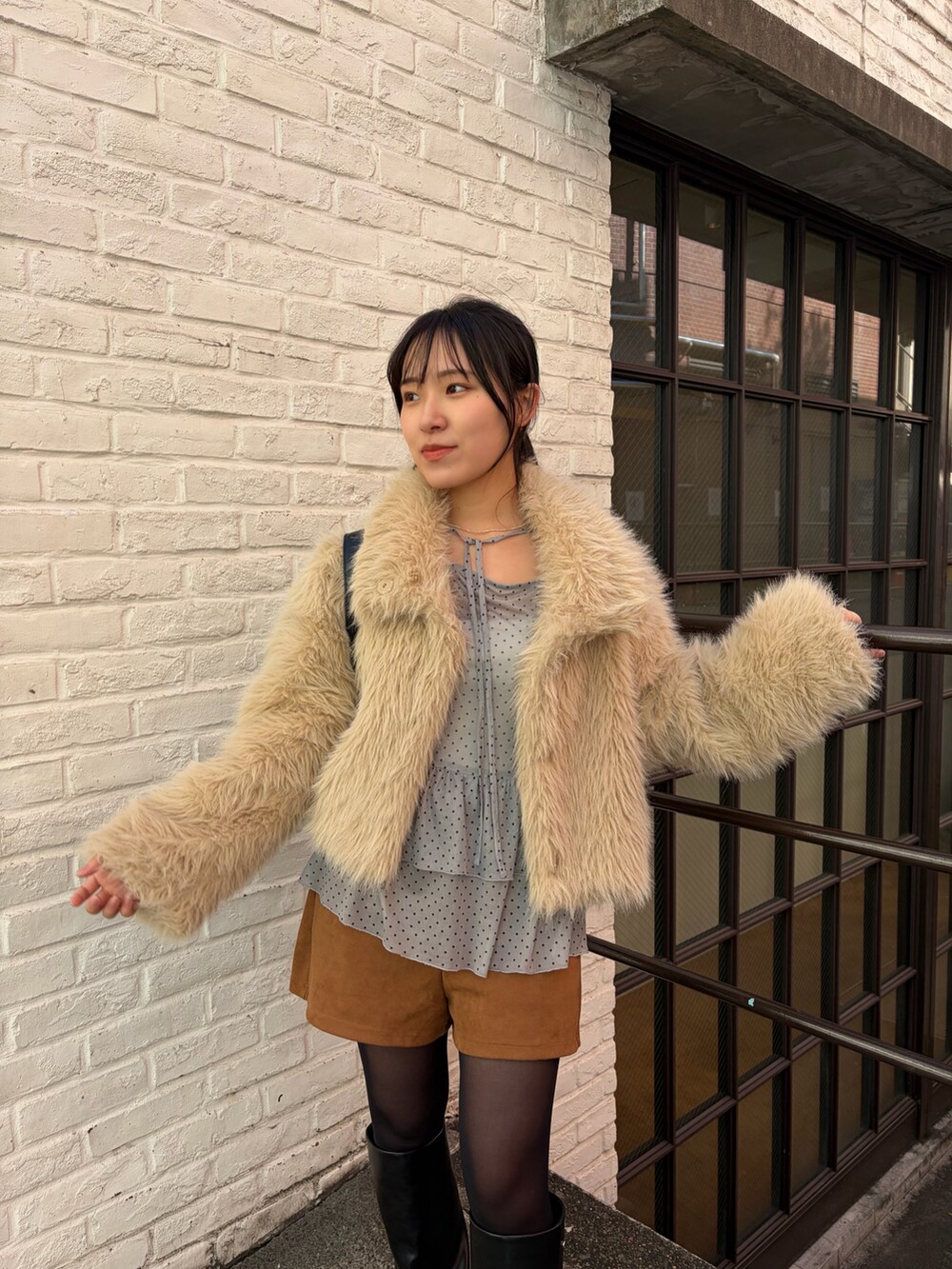 ベージュ系のその他アウター、イエロー系のその他パンツ、ブラック系のブーツを着用したレディースの冬コーディネートの3枚目の写真