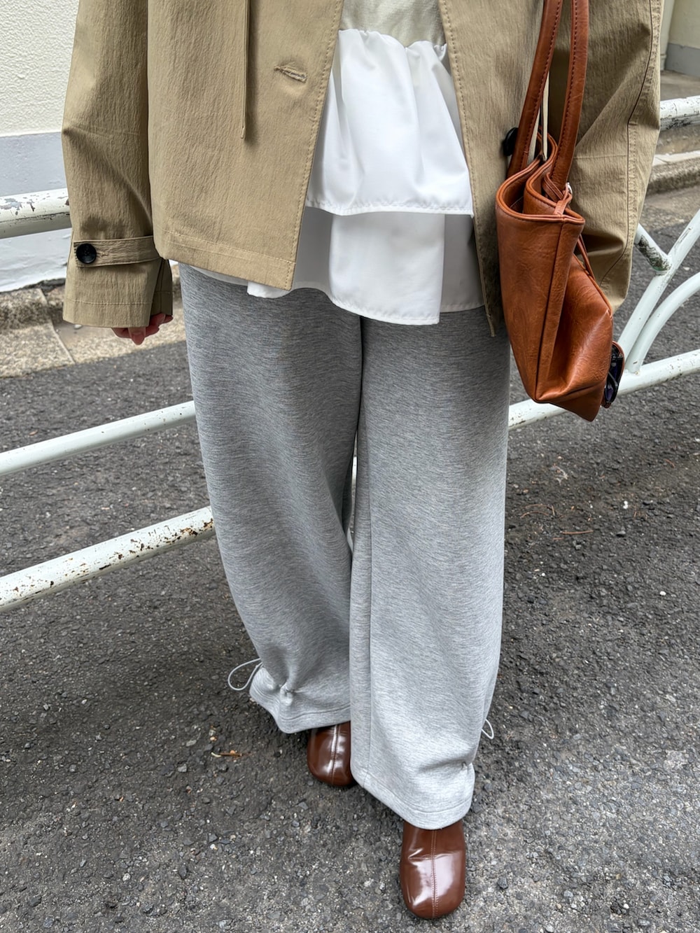 グレー系のスウェットパンツ、ブラウン系のブーツ、イエロー系のトートバッグを着用したレディースの冬コーディネートの6枚目の写真