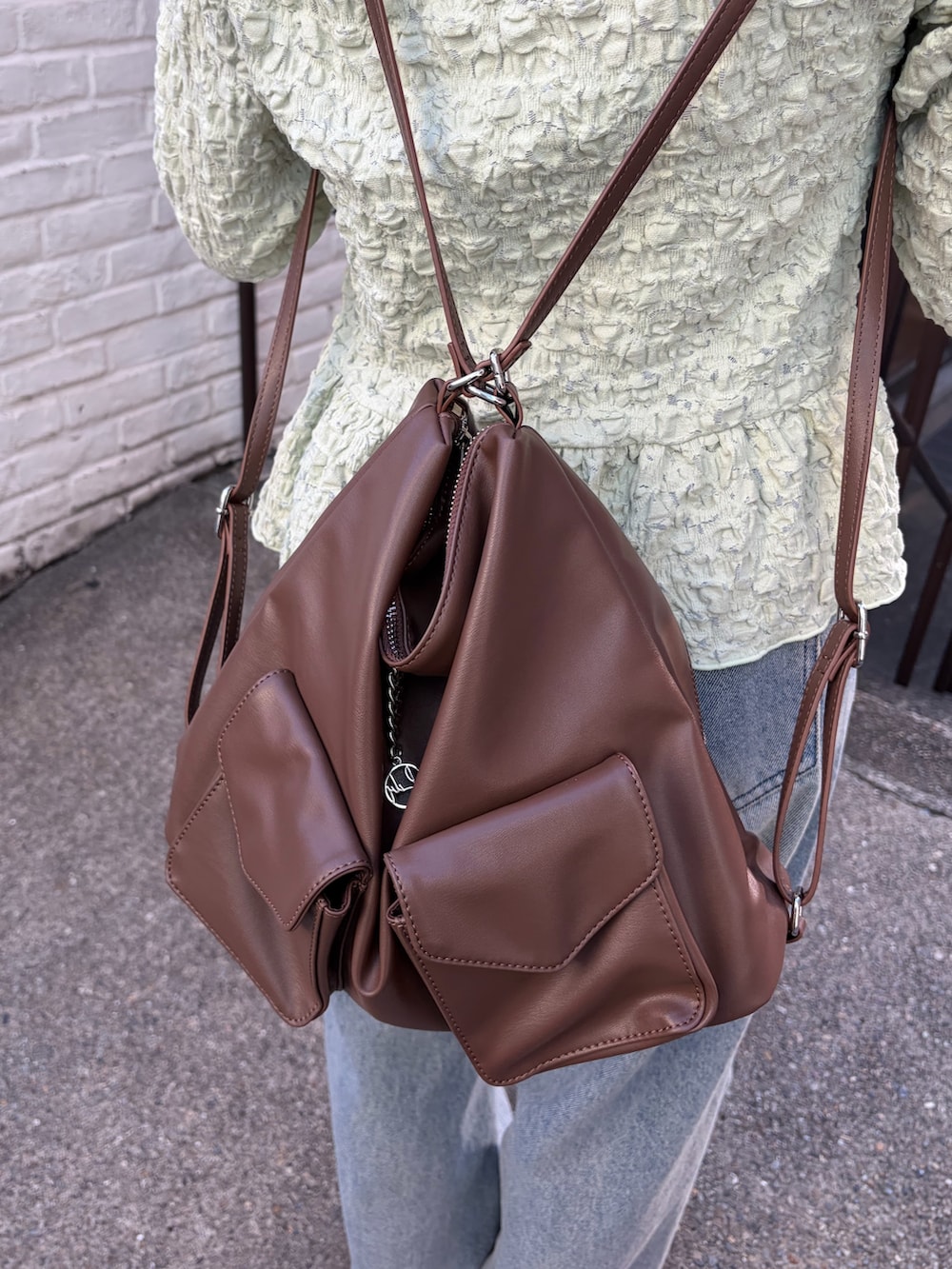 グリーン系のシャツ/ブラウス、イエロー系のトートバッグ、ブルー系のデニムパンツを着用したレディースの冬コーディネートの7枚目の写真