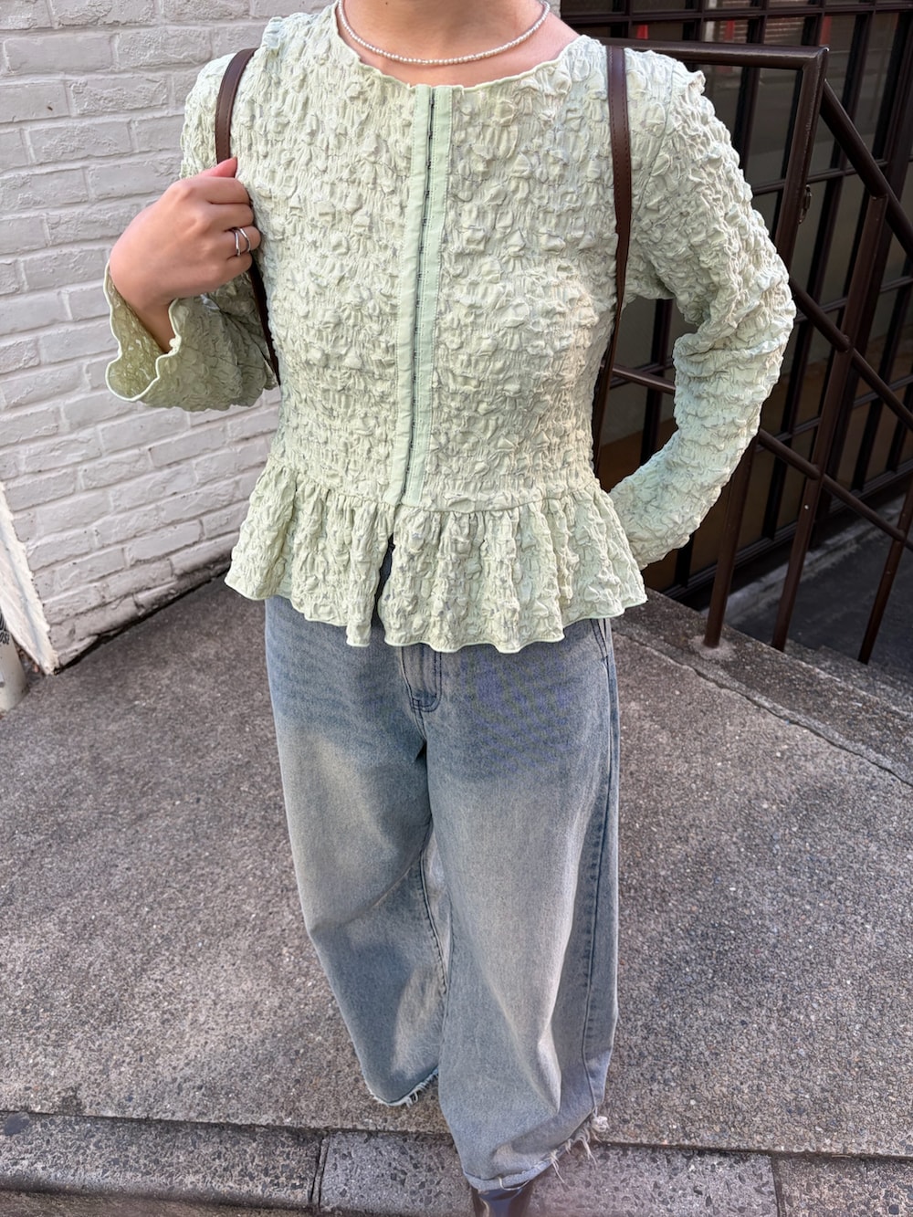 グリーン系のシャツ/ブラウス、イエロー系のトートバッグ、ブルー系のデニムパンツを着用したレディースの冬コーディネートの4枚目の写真