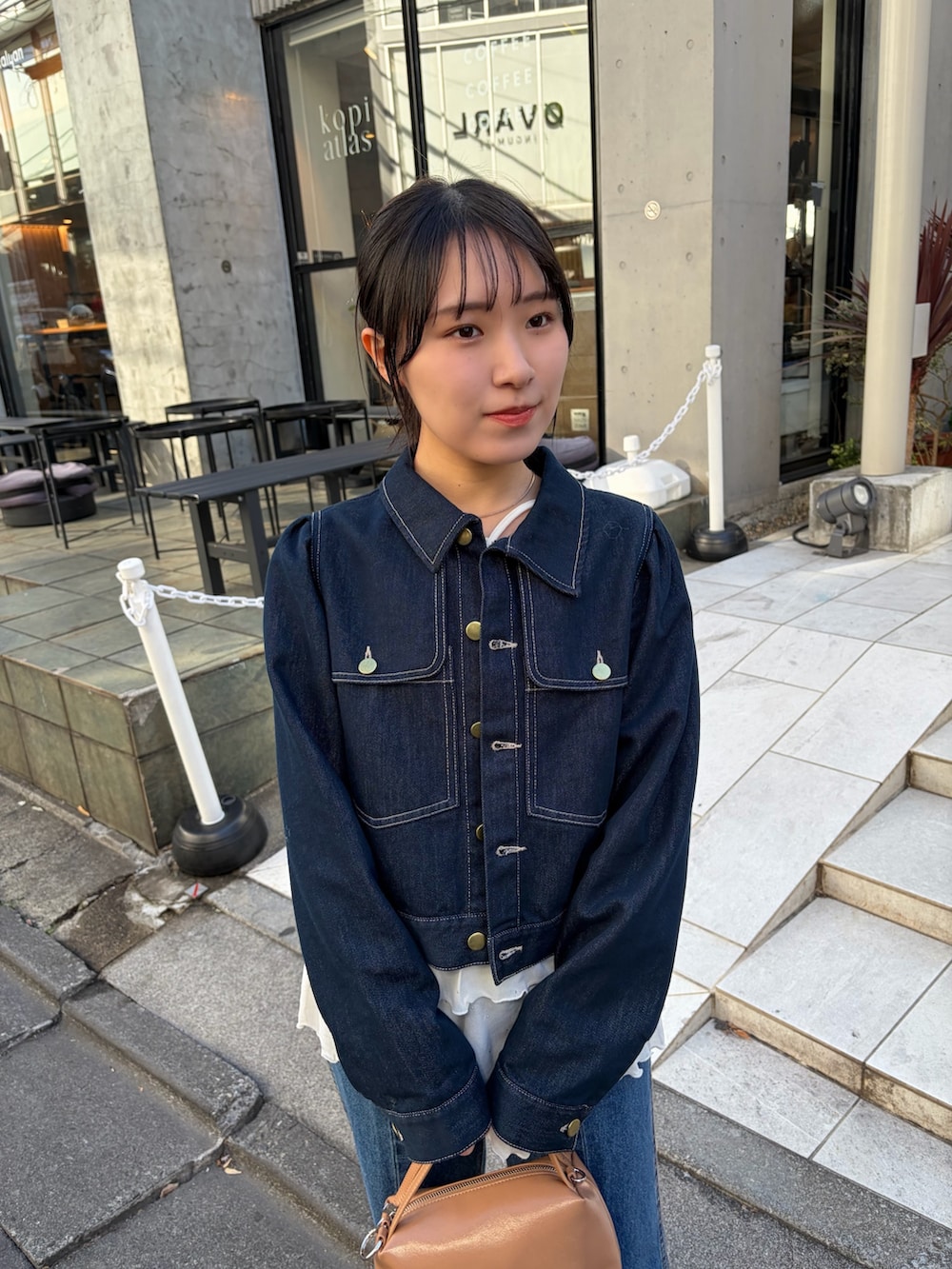 ホワイト系のTシャツ/カットソー、ブルー系のデニムジャケット、ブラック系のブーツを着用したレディースの冬コーディネートの3枚目の写真