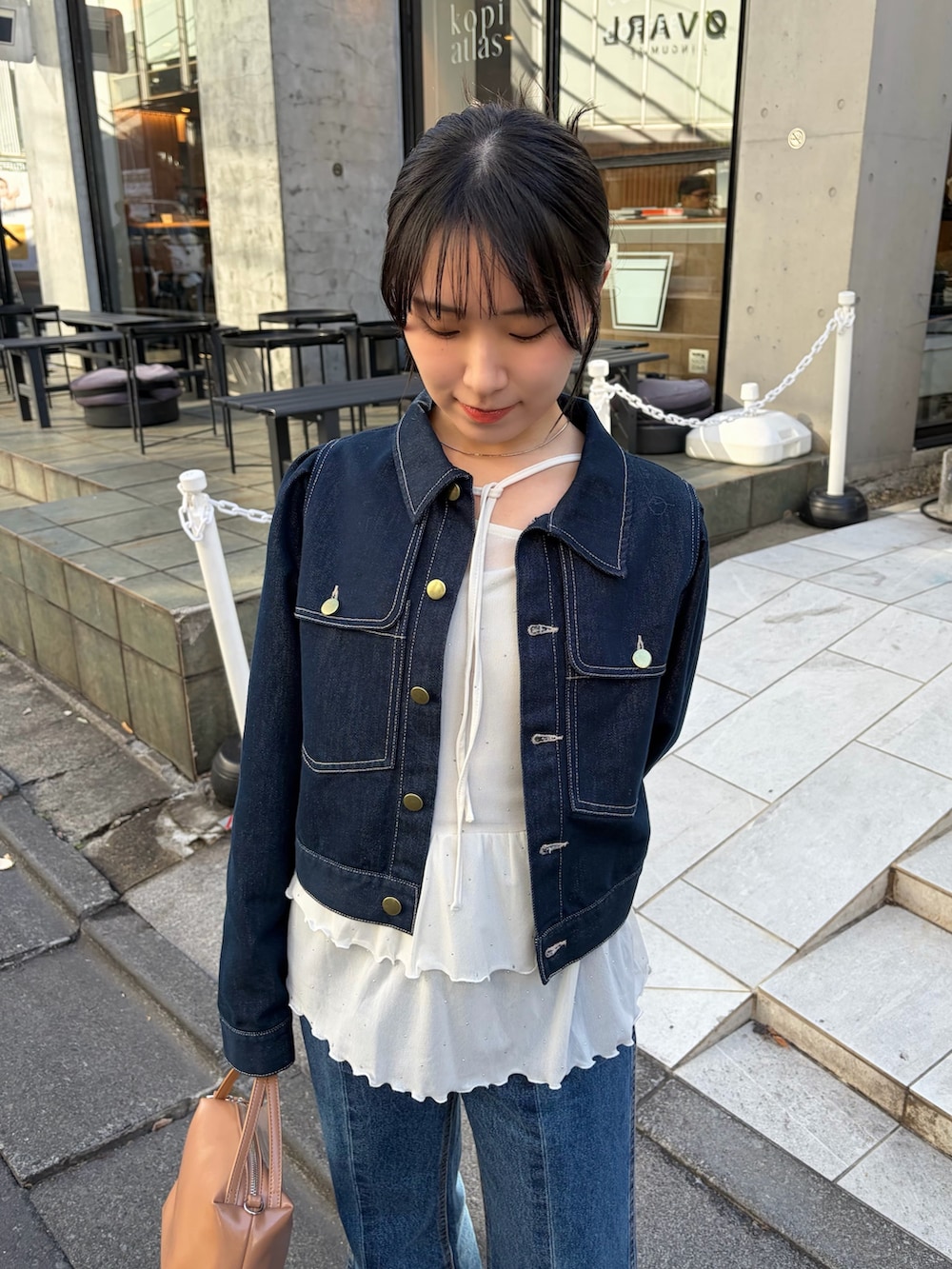 ホワイト系のTシャツ/カットソー、ブルー系のデニムジャケット、ブラック系のブーツを着用したレディースの冬コーディネートの2枚目の写真