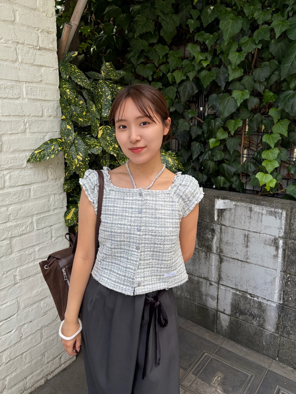 グレー系のその他パンツ、ブラウン系のバックパック/リュック、グレー系のTシャツ/カットソーを着用したレディースの夏コーディネートの2枚目の写真