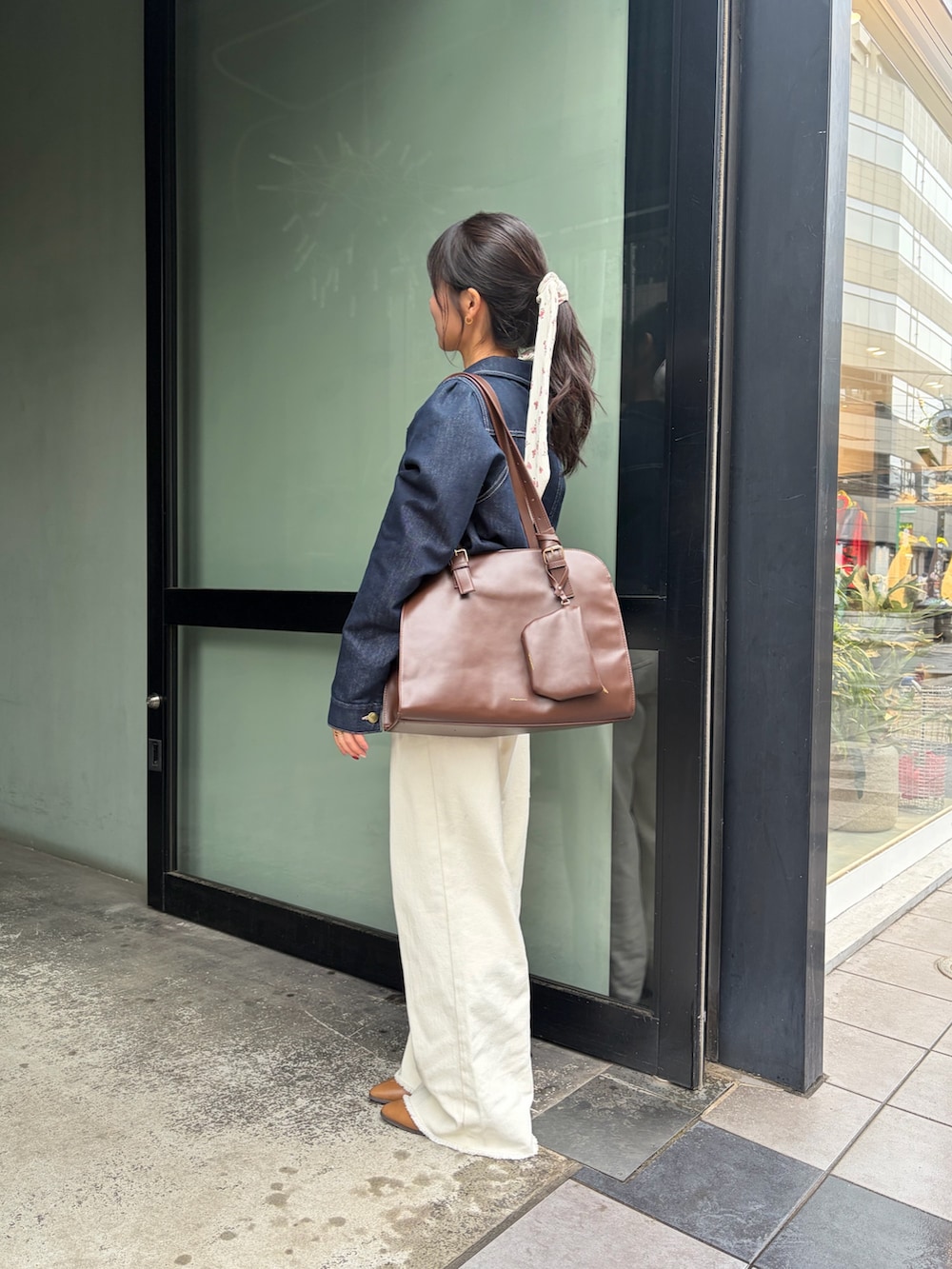 イエロー系のブーツ、ブルー系のブルゾン、ブラウン系のトートバッグを着用したレディースの冬コーディネートの2枚目の写真