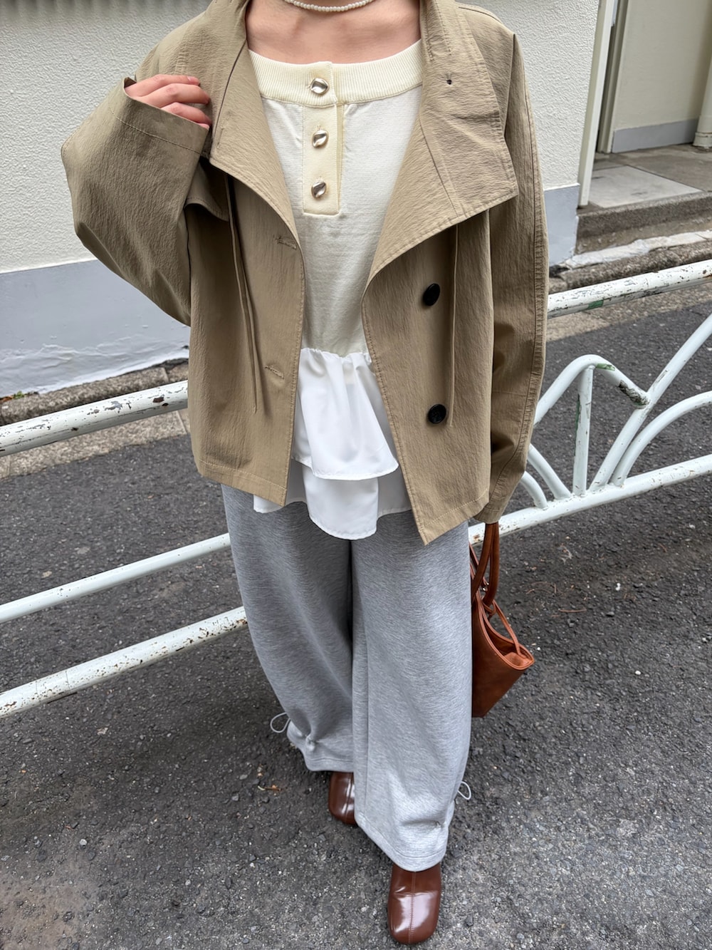 グレー系のスウェットパンツ、ブラウン系のブーツ、イエロー系のトートバッグを着用したレディースの冬コーディネートの4枚目の写真