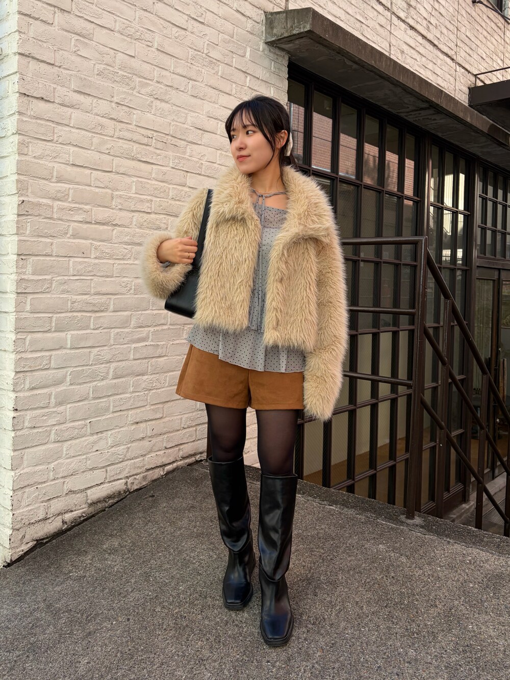 ベージュ系のその他アウター、イエロー系のその他パンツ、ブラック系のブーツを着用したレディースの冬コーディネートの2枚目の写真