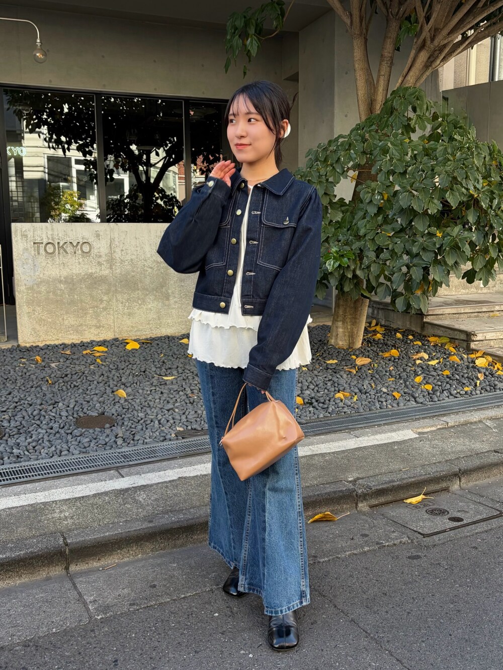 ホワイト系のTシャツ/カットソー、ブルー系のデニムジャケット、ブラック系のブーツを着用したレディースの冬コーディネートの4枚目の写真