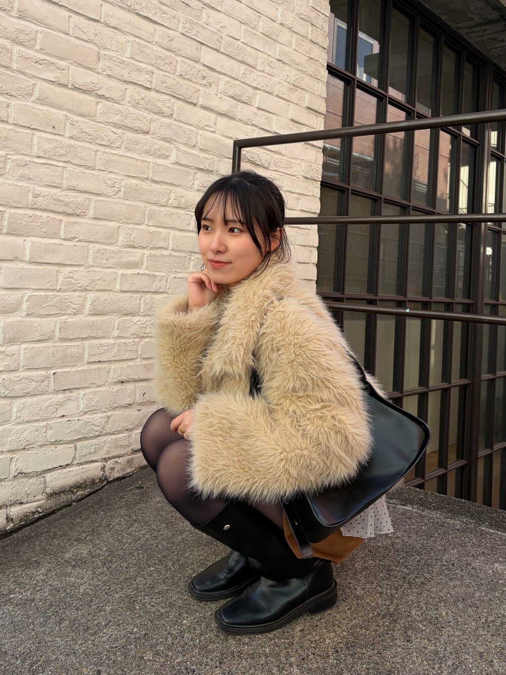 ベージュ系のその他アウター、イエロー系のその他パンツ、ブラック系のブーツを着用したレディースの冬コーディネートの4枚目の写真