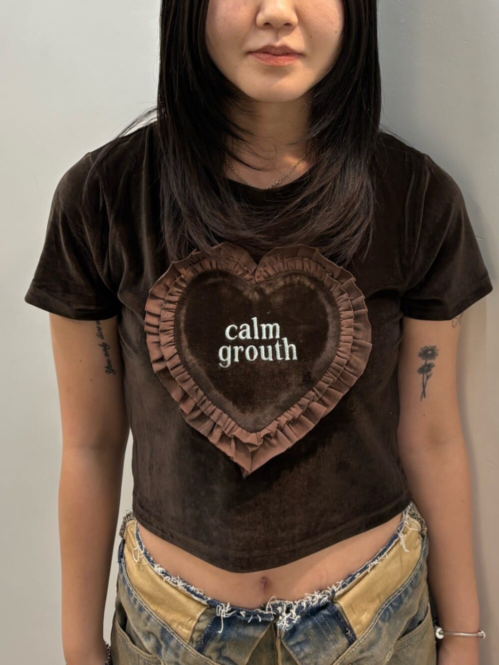 ブラウン系のデニムパンツ、ブラウン系のTシャツ/カットソー、ブラック系のスリッポンを着用したレディースの夏コーディネートの4枚目の写真